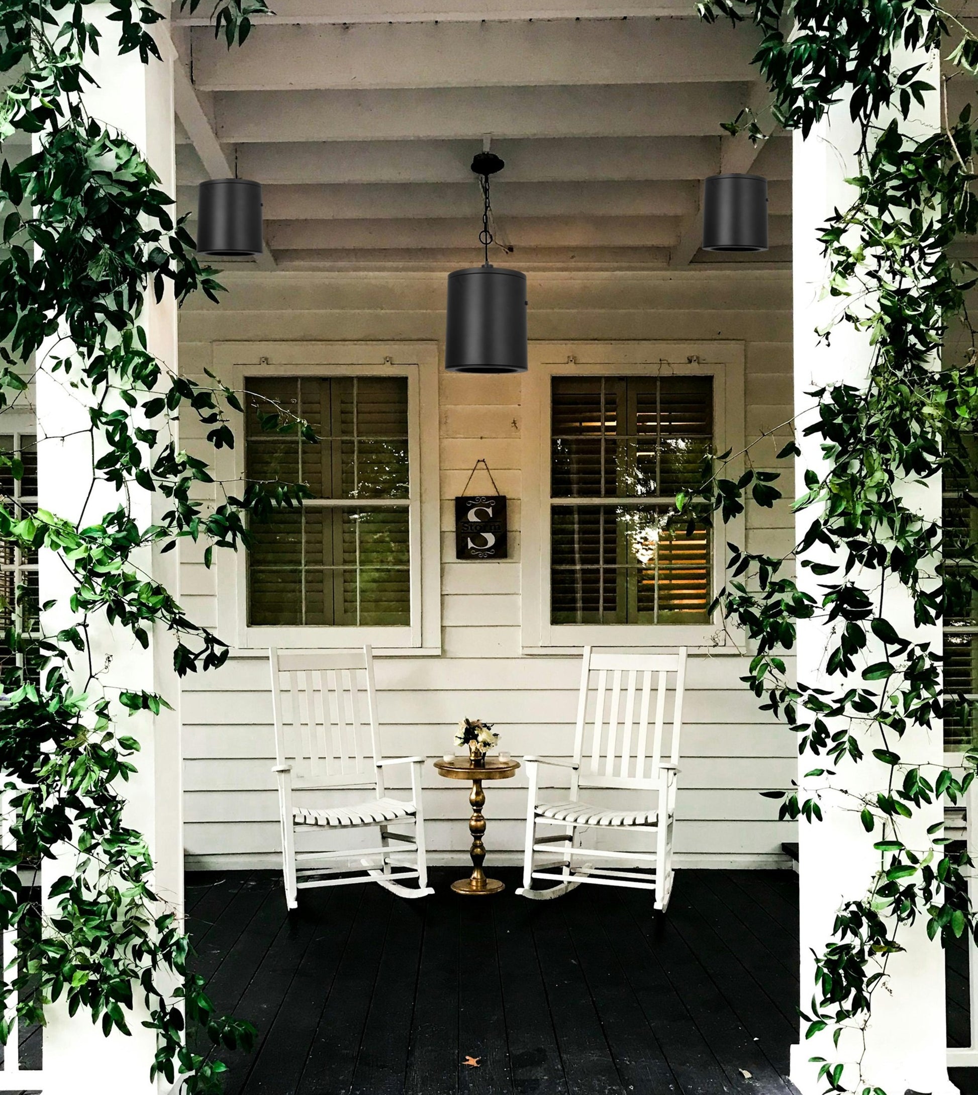 3-pack modern dimmable LED pendant cylinder lights with 3CCT adjustable, featuring both hanging and surface-mounted installation on the ceiling of a front porch, with white rocking chairs, a small table, and hanging lights, framed by greenery, suitable for damp locations, black matte finish, and adjustable hanging height