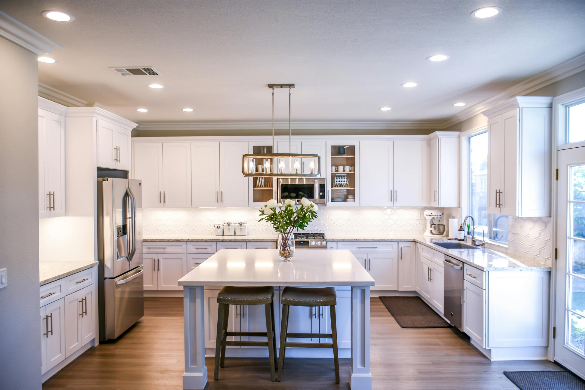 Elegant modern kitchen with white cabinetry illuminated by ultra slim LED recessed downlights providing soft, even, and energy-efficient ceiling lighting.