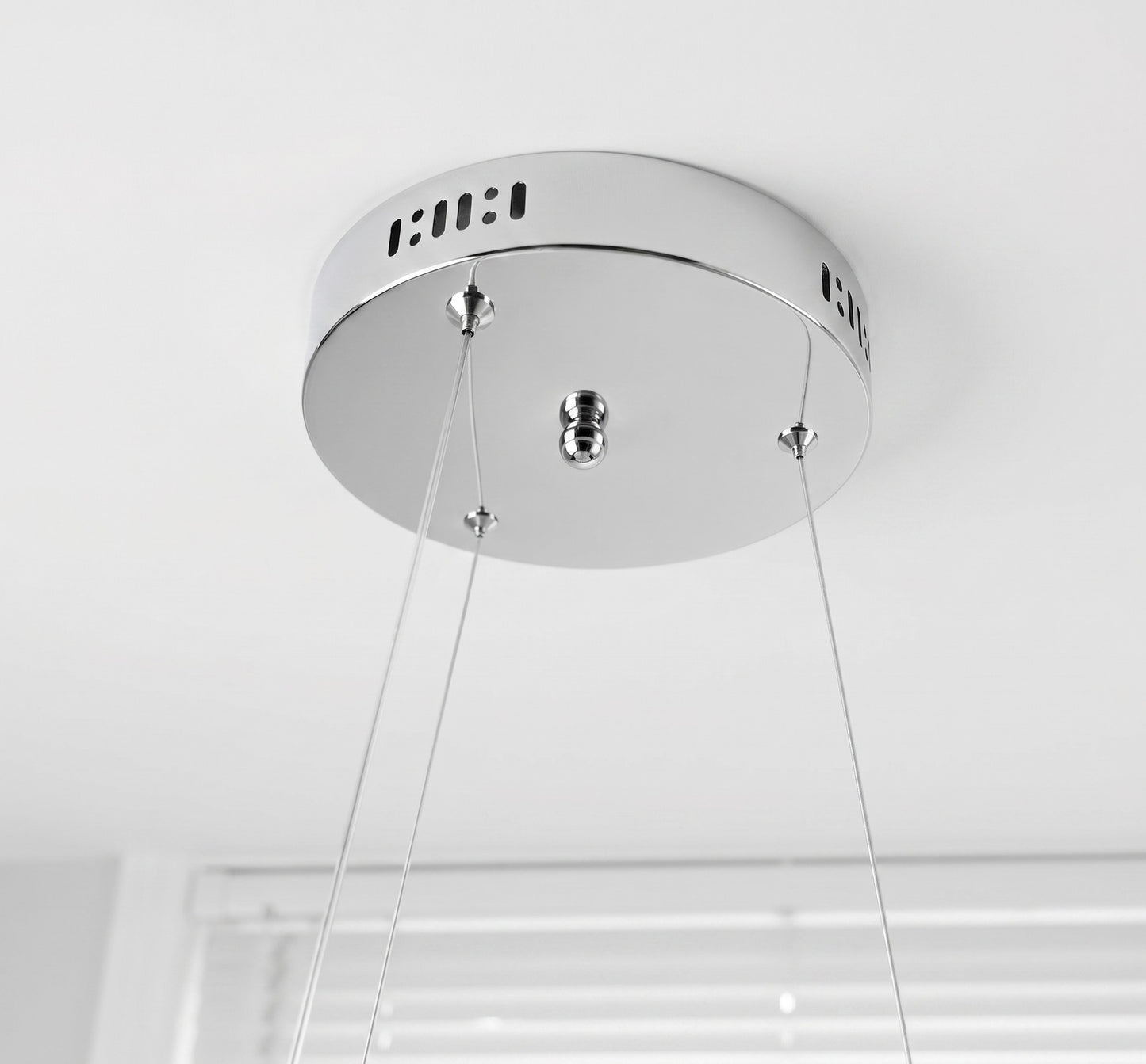 Modern LED swirl chandelier showing adjustable suspension cables and ceiling mounting connection
