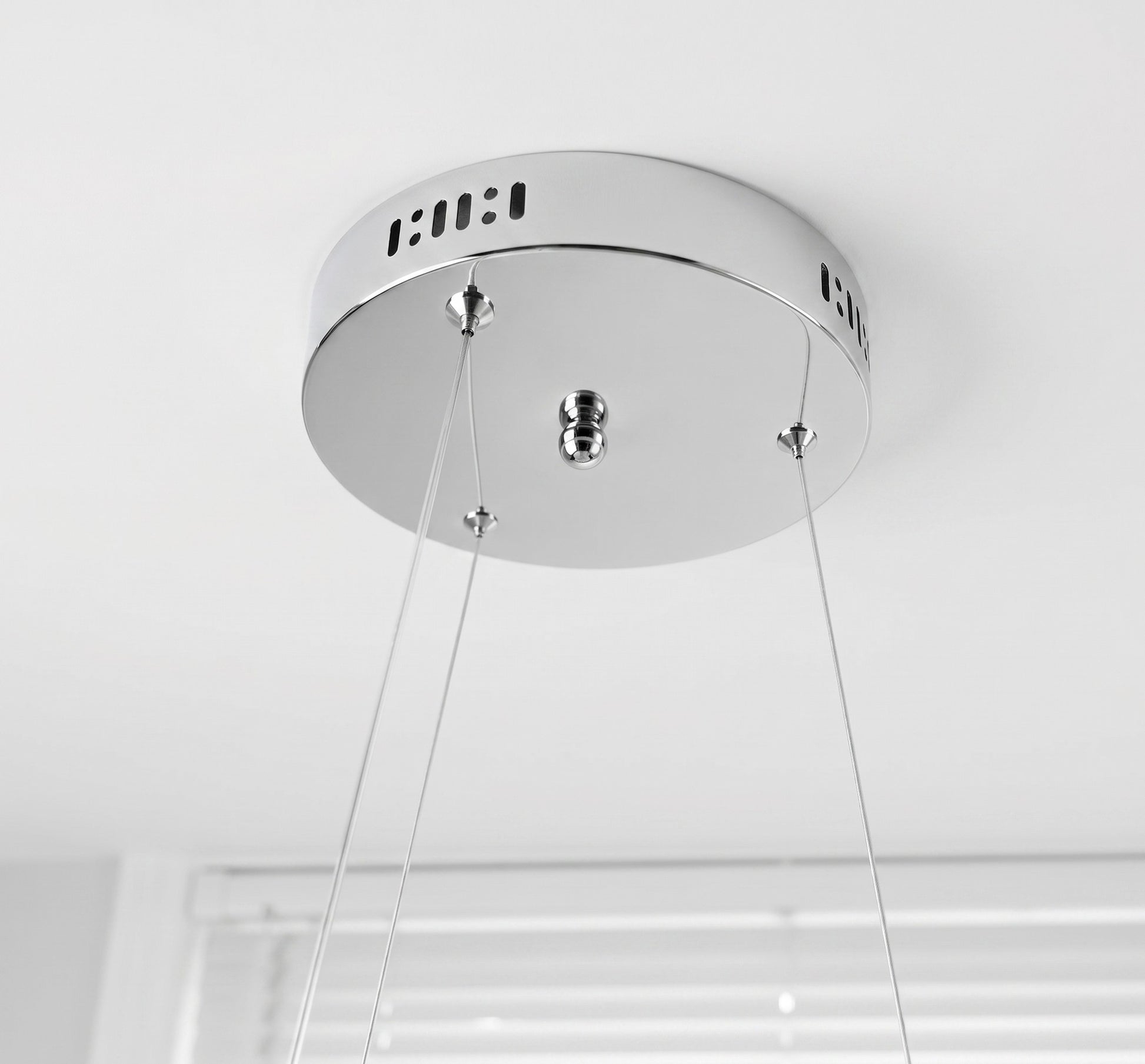 Modern LED swirl chandelier showing adjustable suspension cables and ceiling mounting connection