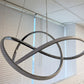 Close-up of modern LED swirl chandelier showing aluminum frame and frosted diffuser detail