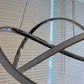 Close-up of modern LED swirl chandelier showing the sculptural swirl design and frosted diffuser when off